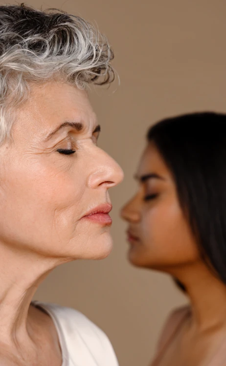 Profilporträt einer älteren Frau mit geschlossenen Augen, im Hintergrund eine jüngere Frau ebenfalls im Profil